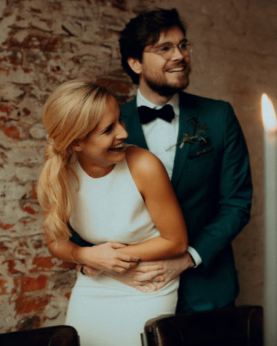 Lachendes Ehepaar bei der Hochzeit mit zweifarbigen Eheringen von Jan Spille Schmuck