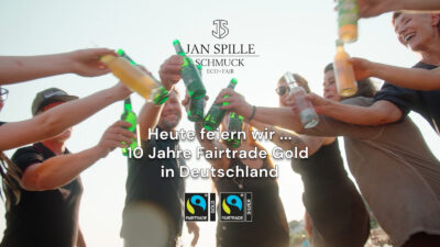 teaser bild jan spille team stößt mit bier an darüber die headline heute feiern wir... 10 Jahre Fairtrade Gold in Deutschland