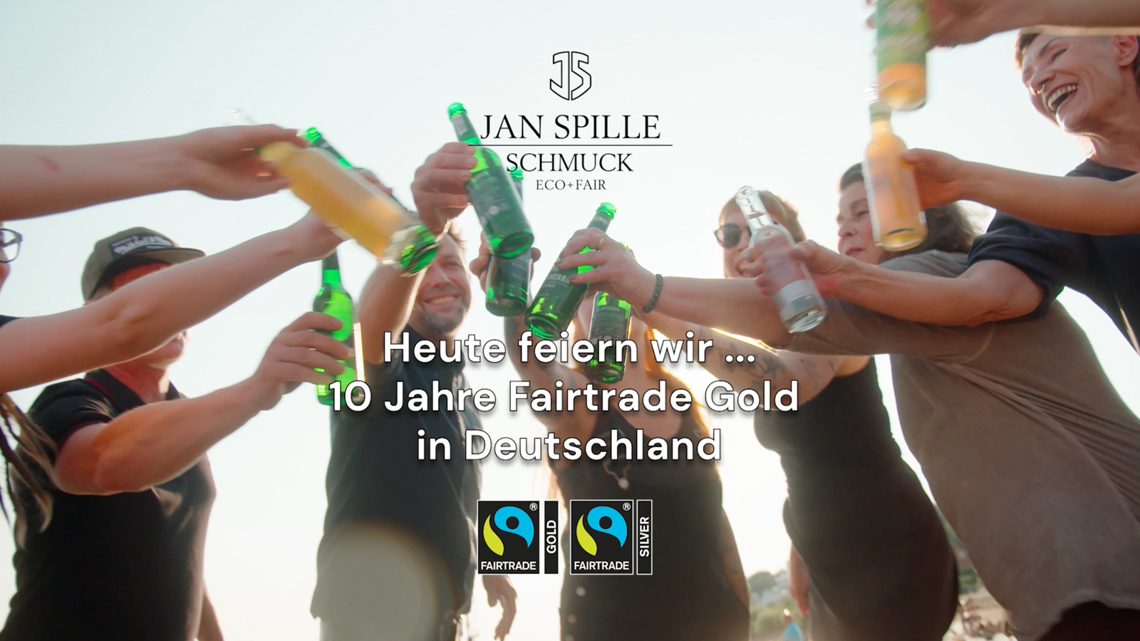 teaser bild jan spille team stößt mit bier an darüber die headline heute feiern wir... 10 Jahre Fairtrade Gold in Deutschland