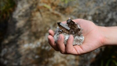 Eine Stufe aus fairen Rauchquarzen wird in einer Hand präsentiert