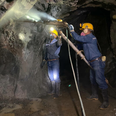 MInenarbeiter Iquira bringen Sprengladung mit Bohrmaschine an