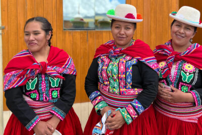 Peruanische Tänzerinnen vor Minenarbeiter Wohnungen