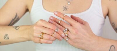 Frau trägt an beiden Händen viele Ringe mit Krappenfassung aus der Chaton Kollektion von Jan Spille schmuck vom goldschmied