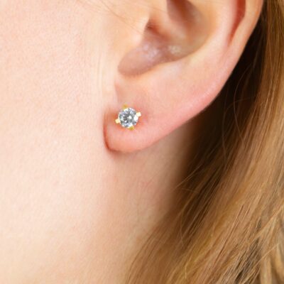 Nahaufhame eines Ohres mit Grafischem Design Ohrstecker aus Fairtrade Gold mit konfliktfreiem Diamanten in Krappenfassung