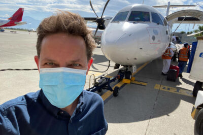 Jan Spille mit Corona Atemschutzmaske auf Rollfeld vor Flugzeug in Kolumbien