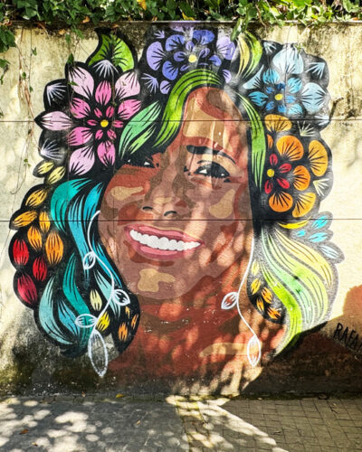 streetart bildnis einer frau mit buntem blumenschmuck im haar als mood bild für brasilianische diversity schmuck kollektion von jan spille