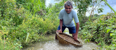 Bergbaurarbeiter wäscht Edelsteine mit Waschschüssel im Fluss in einer Saphirmine in Sri Lanka für Ecofaire Edelsteine