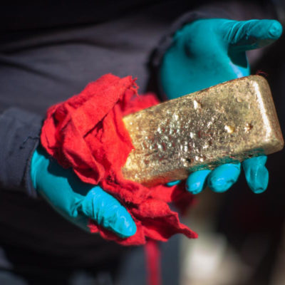 Faire Bergbaureisen nach Peru Minenmitarbeiter zeigt Fairtrade Goldbarren in der Hand