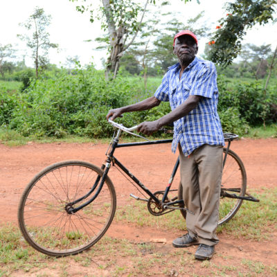 Mann mit Fahrrad in Uganda, , während fairer Bergbaureise von Jan Spille