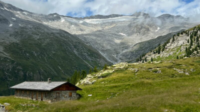 Almwiese mit Berghütte in den italienischen Alpen