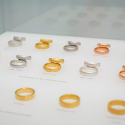 Trauringmodelle mit unterschiedlichen Ringoberflächen in einer Schmuckvitrine von Goldschmied Jan Spille