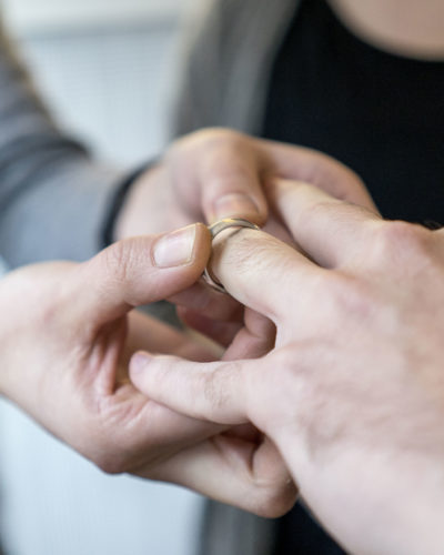 Schmuckberaterin prüft einen Trauringe auf die richtige Ringgrösse