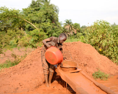 junge im matsch beim konventionellen goldabbau in afrika
