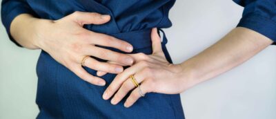 Frau posiert mit Wickelringe als Verlobungsring mit kleinem Stein aus Ökogold von jan Spille aus Hamburg Altona