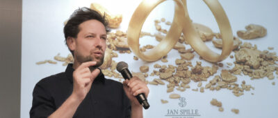 goldschmied jan spille mit mikro in der hand bei einem vortrag über nachhaltigen schmuck