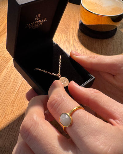 Ein Kettenanhänger aus Fairmined Gold auf dem die Olypmischen Ringe graviert wurden