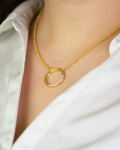 Detailaufnahme eines Ausschnitts mit goldener Kette mit Anhänger in zeitloser Schmuck Kollektion Pavé von jan Spille in Hamburg
