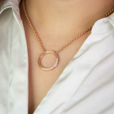 Ausschnitt einer Person mit zeitloser Schmuck Kette mit rundem Anhänger Recycling Gold im Pavé von jan Spille in Hamburg
