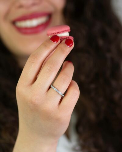 Frau hält Rose Macaron und trägt Verlobungsring aus Fairtrade Echtgold im Pavé mit konfliktfreien Naturdiamanten