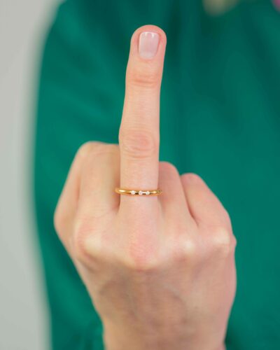 Frau zeigt Mittelfinger mit gold ring rund Fuck konventionelles Gold! Kauft Faires Gold!