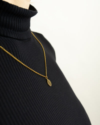 seitenansicht von coin kette gold auf schwarzem pullover für gravur schmuck hamburg von jan spille