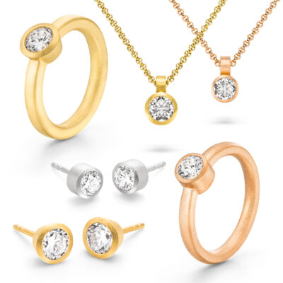 ringe ketten und ohrstecker in weißgold roségold und gelbgold abgebildet mit diamant in zargenfassung aus der spotlight kollektion von jan spille