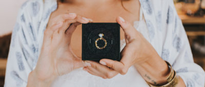 frau hält ringbox mit verlobungsring von jan spille in die kamera